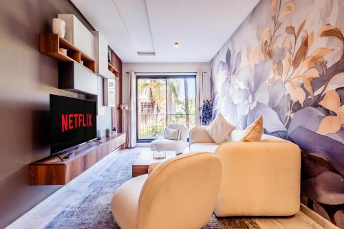 a living room with a couch and a tv at Résidence Cerezo in Maarif