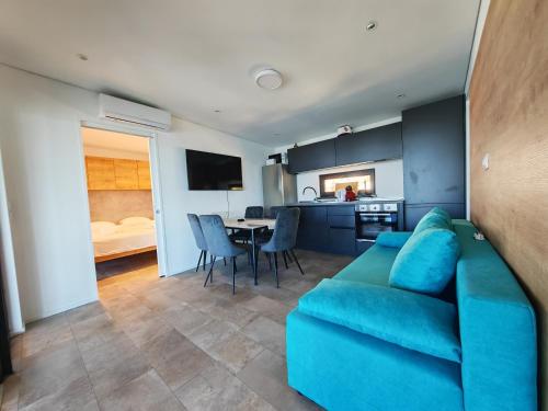 a living room with a blue couch and a kitchen at Sea view Anika by Vellaris, Luxury Mobile Home in Mali Lošinj