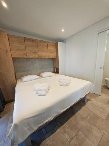 a bedroom with a large white bed with towels on it at Sea view Anika by Vellaris, Luxury Mobile Home in Mali Lošinj