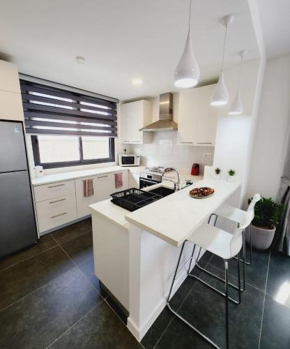a kitchen with white cabinets and a black refrigerator at Beautiful 3 Bedroom Townhome in Teiman