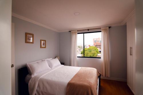 a bedroom with a bed and a window at Dpto. San Andrés, la mejor vista y ubicación in Cuenca