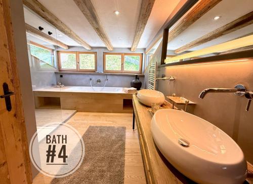 a bathroom with two sinks and a bath tub at DER ERLACHER Alpenrefugium 1874 LUXERY & PRIVACY by Belle-Stay in Jochberg