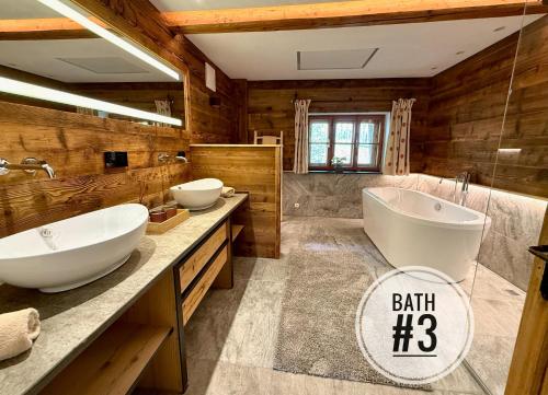 a bathroom with two sinks and a large tub at DER ERLACHER Alpenrefugium 1874 LUXERY & PRIVACY by Belle-Stay in Jochberg