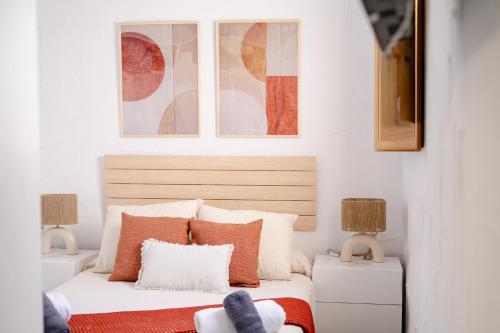 a bedroom with a bed with orange and white pillows at El Tablao in Jerez de la Frontera