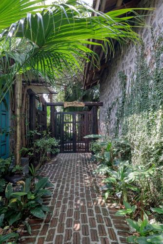 a brick walkway in a garden with plants at ChezCao Rice Field Ecolodge Ninh Binh in Ninh Binh