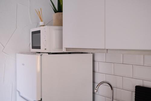 a microwave on top of a refrigerator in a kitchen at El Tablao in Jerez de la Frontera