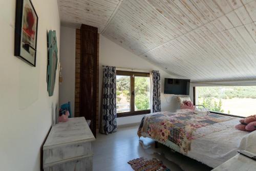 a bedroom with a bed and a large window at Villa El Desbarbado 