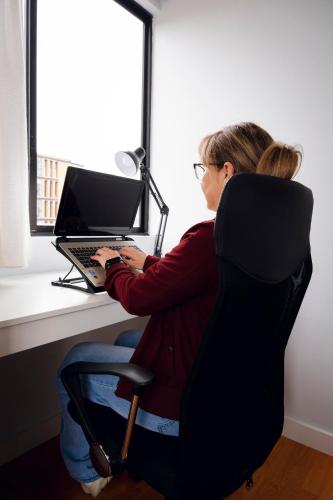 a woman sitting at a desk with a laptop computer at Dpto. San Andrés, la mejor vista y ubicación in Cuenca