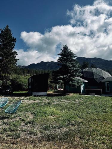 a field with two chairs in front of a house at Riverside Tiny Home with Dynamite Views in Bailey