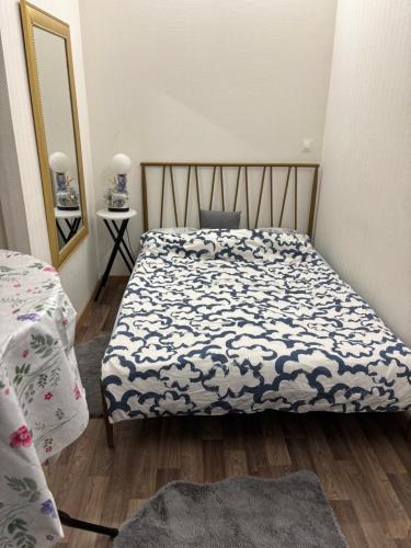 Un dormitorio con una cama con un edredón azul y blanco. en Bien venu au studio B, en Clichy