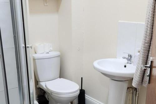 a white bathroom with a toilet and a sink at 1 Bed - Sleeps 4 - Wolverhampton City Centre in Wolverhampton