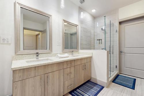 Un baño con lavabo doble y ducha. en The Pointe 131, en Inlet Beach