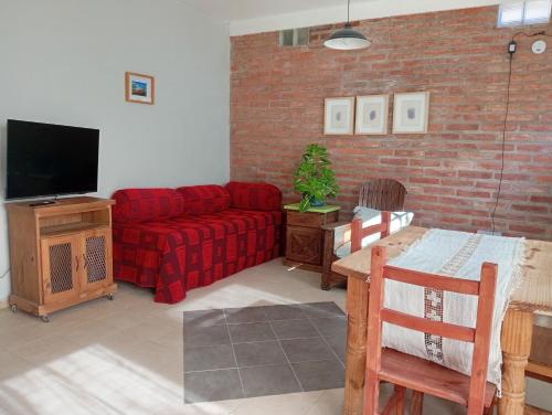 un salon avec un canapé rouge et une télévision dans l'établissement Casa Boreal dptos estilo casa, à Puerto Madryn