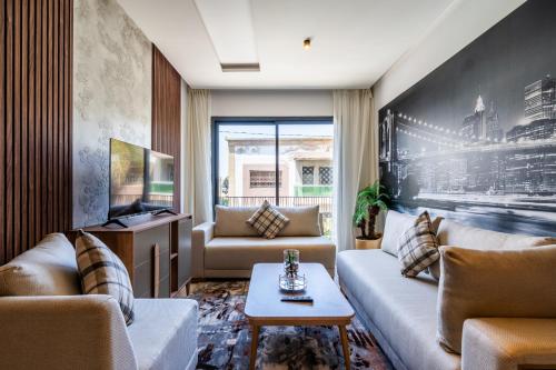 a living room with two couches and a tv at Résidence Cerezo in Maarif