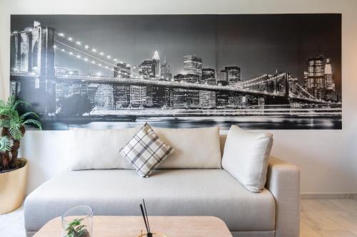 a couch in a living room with a picture of a bridge at Résidence Cerezo in Maarif