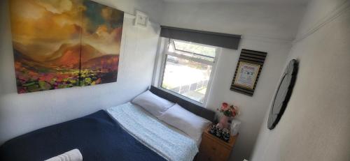 a small room with a bed and a window at Lovely room like a home away home near the airport in Wythenshawe