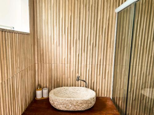 a bathroom with a stone sink in a shower at Pousada Valle Verde in Cabo Frio