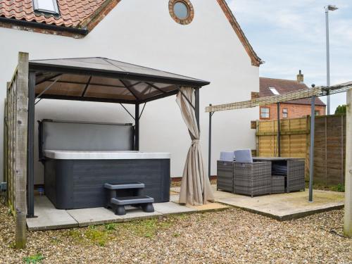 ein Pavillon und ein Grill in einem Hinterhof in der Unterkunft Garden Cottage in Nafferton