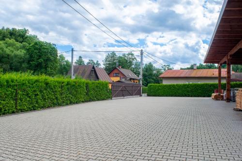 a driveway with a hedge and a house in the background at Penzion K in Rudník