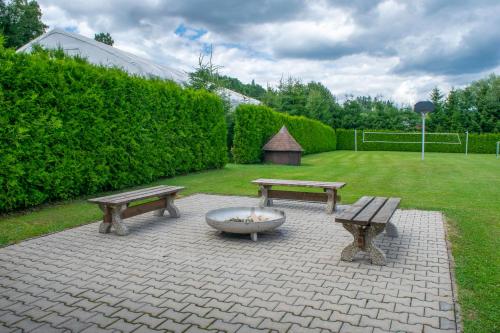 a patio with two benches and a bowl and a fountain at Penzion K in Rudník