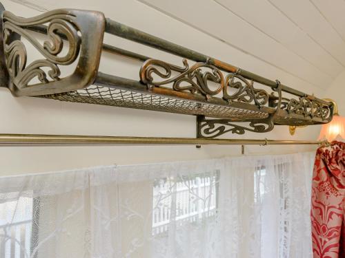 a curtain rod attached to a wall with a window at Sprat & Winkle in Horsebridge