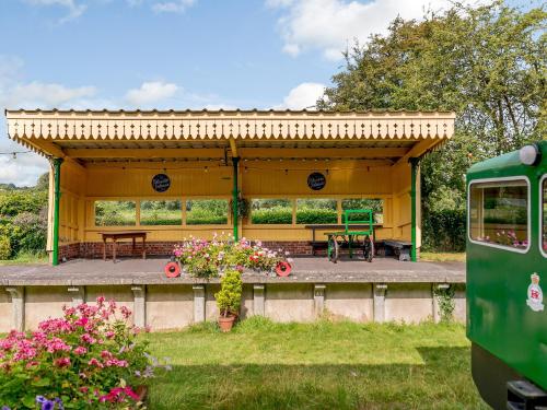 a yellow shed with a picnic table and a bench at Sprat & Winkle in Horsebridge