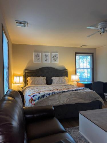 a bedroom with a bed and a leather couch at Carepoint Residence in Lawnside