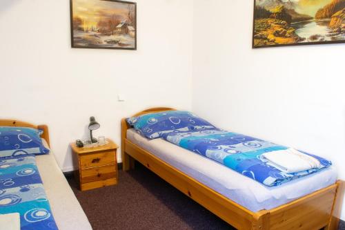 a bedroom with two beds and two pictures on the wall at Penzion K in Rudník