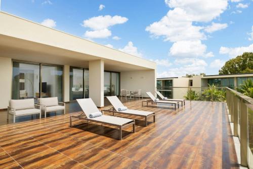 a deck with chairs and tables on a building at Marriott Residences Salgados Resort, Algarve in Albufeira