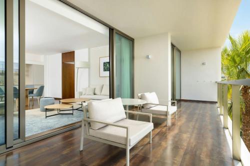 a living room with white chairs and a table at Marriott Residences Salgados Resort, Algarve in Albufeira