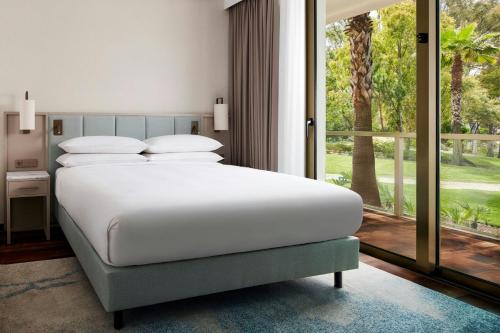 a bedroom with a bed and a large window at Marriott Residences Salgados Resort, Algarve in Albufeira