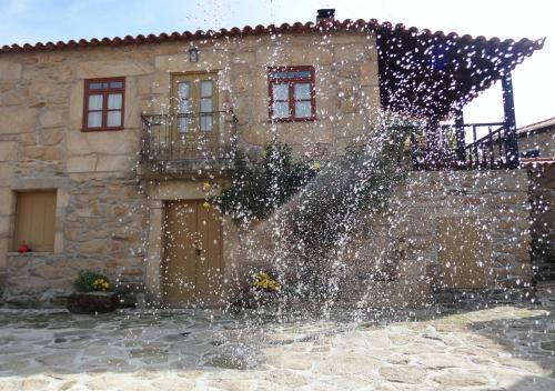 a water fountain in front of a stone building at Casas do Juizo - Country Houses in Juizo