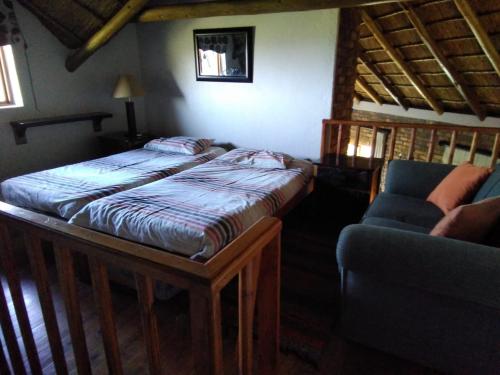 a bedroom with a bed and a couch in a room at Mafuta Lodge - Mabalingwe Nature Reserve in Warmbaths