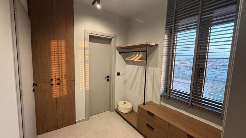 a bathroom with a toilet and a large window at Cityloft Avenue in Mastambás