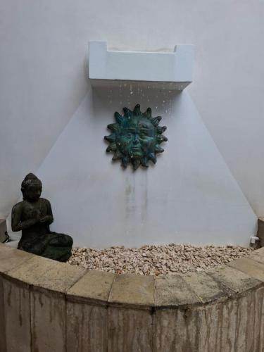 a clock on a wall next to a pile of rocks at Hotel IBIZA Beach Boutique in Jacó