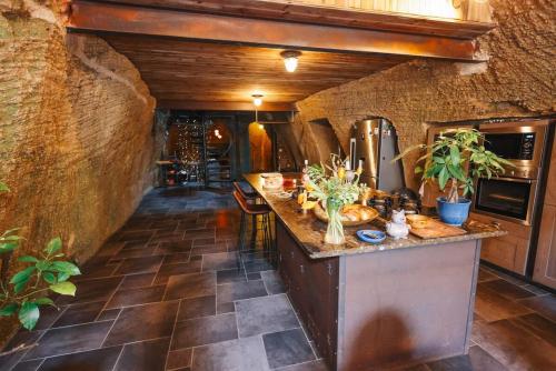 a kitchen with a counter in a stone wall at La Galerie des voûtes oubliées in Doué-la-Fontaine