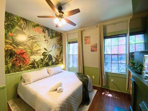 a bedroom with a bed with a ceiling fan at The Jungle Nook - Themed Getaway,Backyard,Grill in Savannah