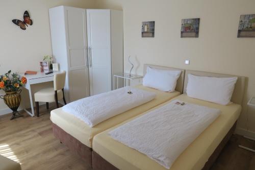 a bedroom with two beds and a table with a butterfly on the wall at Landhotel Bergischer Hof GmbH Marialinden in Overath