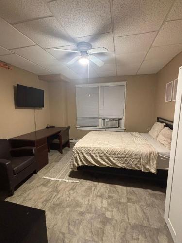a bedroom with a bed and a desk and a tv at Carepoint Residence in Lawnside