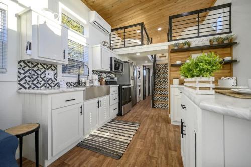 a kitchen with white cabinets and a wooden ceiling at Shadowrock - Luxury Tiny Home with Amazing Views in Yanush