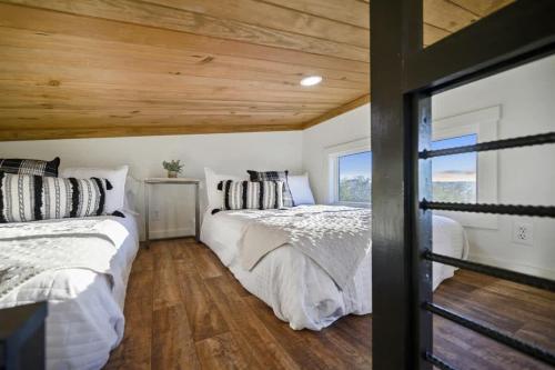 two beds in a bedroom with wooden ceilings at Shadowrock - Luxury Tiny Home with Amazing Views in Yanush