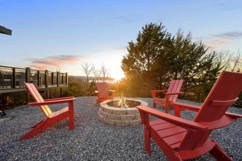 three red chairs sitting next to a fire pit at Shadowrock - Luxury Tiny Home with Amazing Views in Yanush