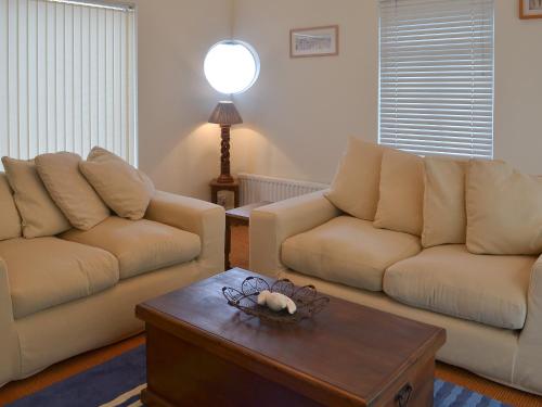 ein Wohnzimmer mit zwei Sofas und einem Couchtisch in der Unterkunft Seacliff Cottage in Strete
