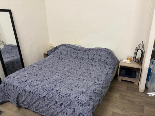 a bedroom with a bed with a blue comforter at Bien venu studio A in Clichy