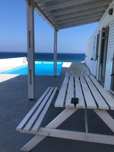 FoinikiáにあるSantorini Grace Villa No1の海を見渡すポーチに座る木製ベンチ