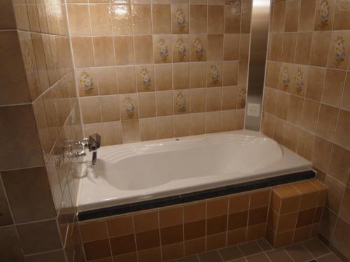 La salle de bains carrelée est pourvue d'une baignoire. dans l'établissement Nuda by H-Seven (Adult Only), à Yokohama