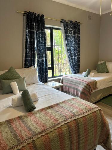 a bedroom with two beds and a window at BlueHive guesthouse in Port Edward
