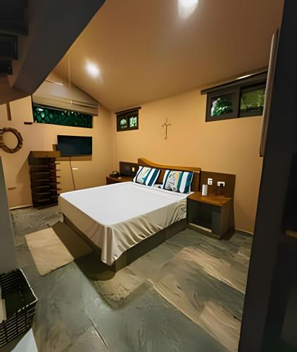 a bedroom with a large bed and a television at Tita Tati Disconnect near Cartagena in Punta Canoas