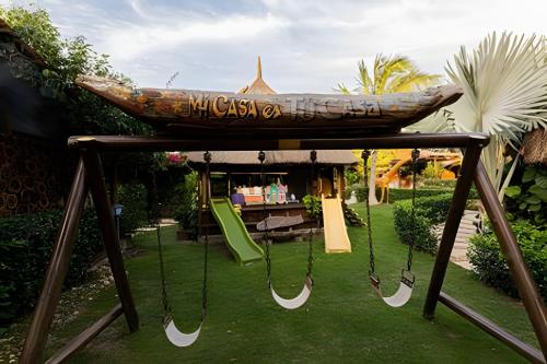 a wooden boat on a swing set in a yard at Tita Tati Disconnect near Cartagena in Punta Canoas