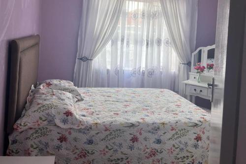 a bedroom with a bed with a floral bedspread at 4 Bed Gated House-Sleeps 8-Private Parking in Harare